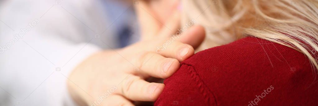 Young male doctor holds sick patient by hand