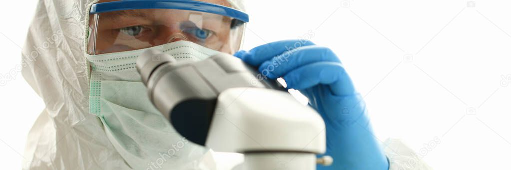 Male chemist in blue protective gloves look