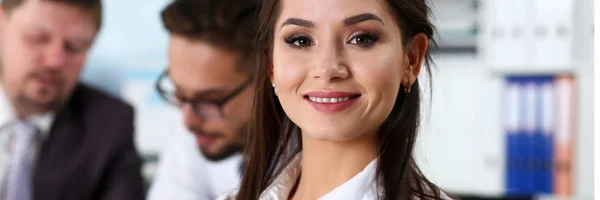 Bella ragazza assistente bruna sorridente sul posto di lavoro — Foto Stock