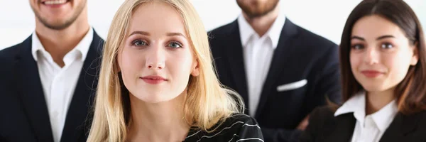 Group of smiling people stand in office looking