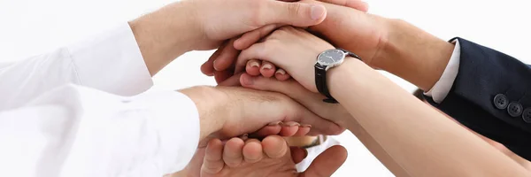 Groep mensen in pakken die gekruiste handen in stapel — Stockfoto