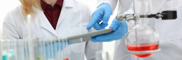 A male doctor in a chemical laboratory holds — Stock Photo, Image