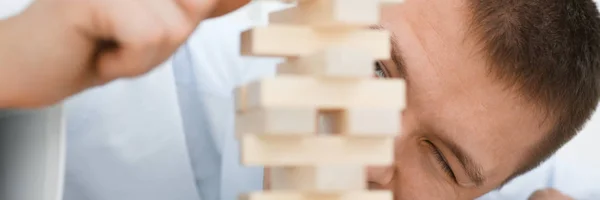 Geschäftsmann spielt mit einer Strategie der Jenga-Hand — Stockfoto