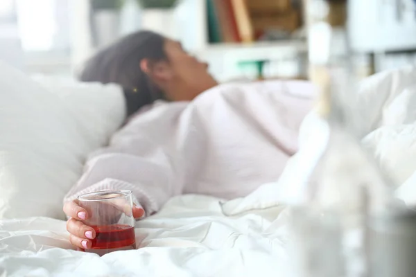 Young woman lying in bed deadly drunken — Stock Photo, Image