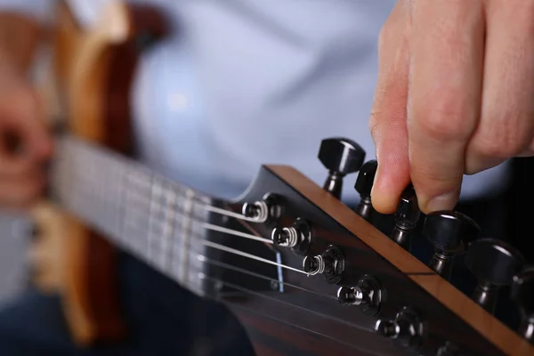 Male arms playing classic shape electric guitar