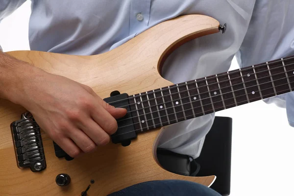 Male arms playing classic shape electric guitar
