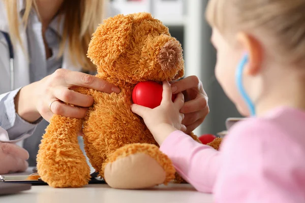 Niña sostener en brazos juguete rojo escuchar jugando con osito de peluche —  Fotos de Stock