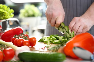 Apron içinde erkek aşçı yeşil salatalık kesti