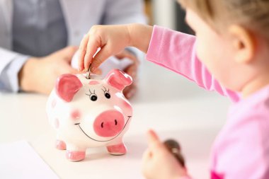 Küçük kız komik domuzcuk banka pin yuvası paraları koyarak el