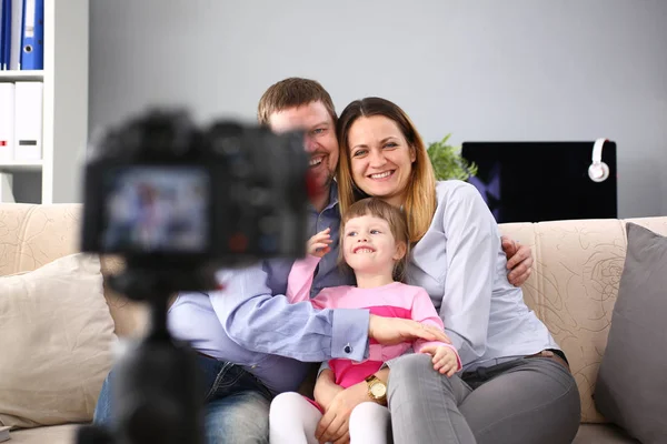Молода щаслива сім'я сидить на дивані роблячи портрет фотосесії — стокове фото
