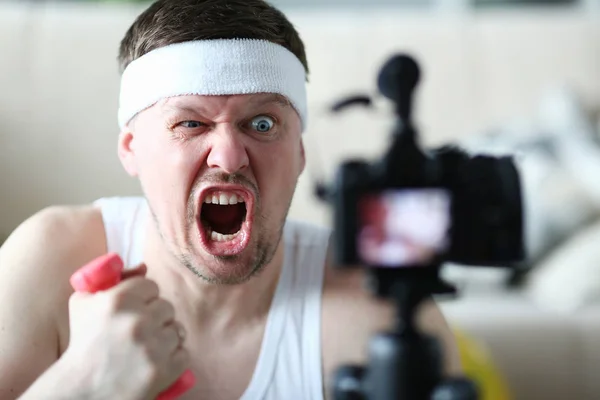 Vlogger masculino sostiene pesas en su —  Fotos de Stock