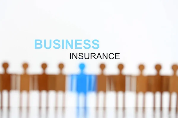 Business insurance sign above line of toy human figures — Stock Photo, Image