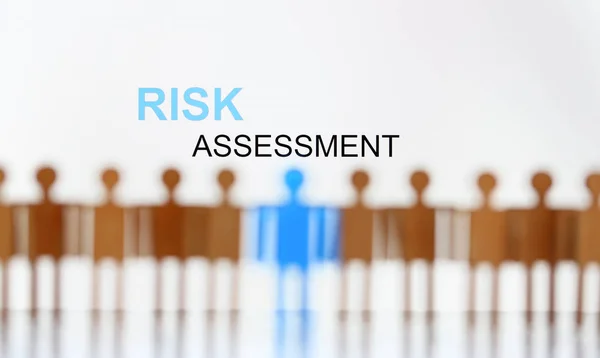 Risk assessment sign above line of toy human figures