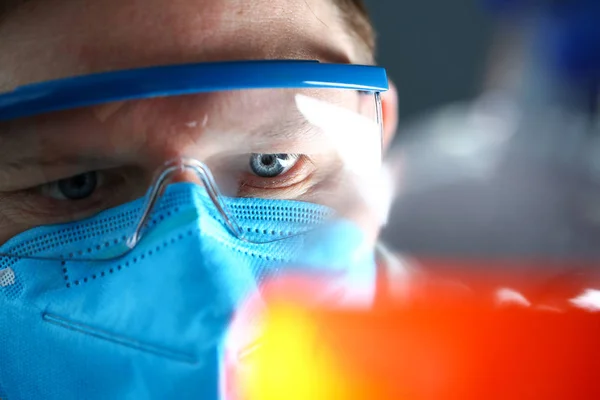 Hombre de laboratorio con máscara protectora en la mano muestra de prueba — Foto de Stock