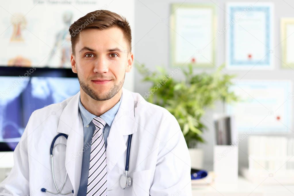 Handsome smiling medicine doctor sitting in office