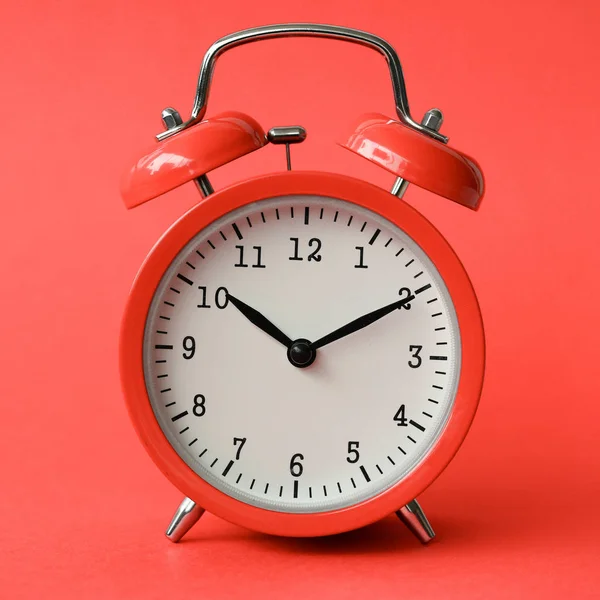 Coral relógio de alarme velho no fundo vermelho — Fotografia de Stock