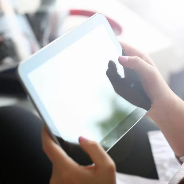 Mão feminina segura tablet em casa, enquanto — Fotografia de Stock