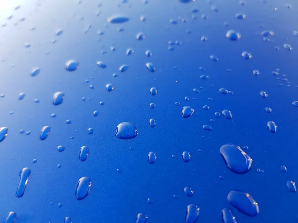 Tropfen Regenwasser auf blauem Metallhintergrund — Stockfoto