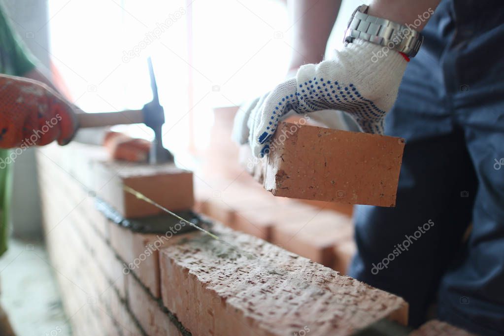 Male builder hand in gloves holding