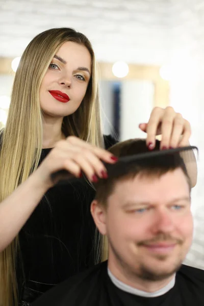 Mujer estilista peinando cliente con cepillo de pelo — Foto de Stock