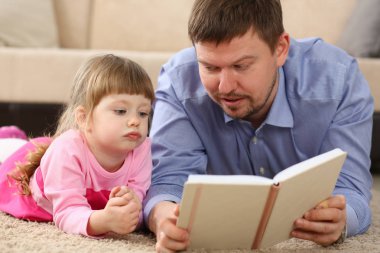 Baba ve kız ilginç bir kitap okuma yere yatın