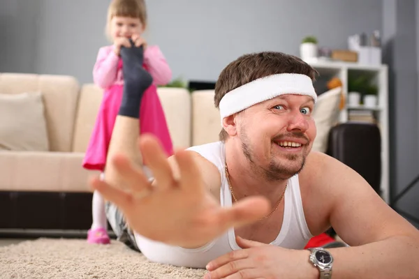 Cute little girl hold her father leg as proof of winning battle game — Stock Photo, Image