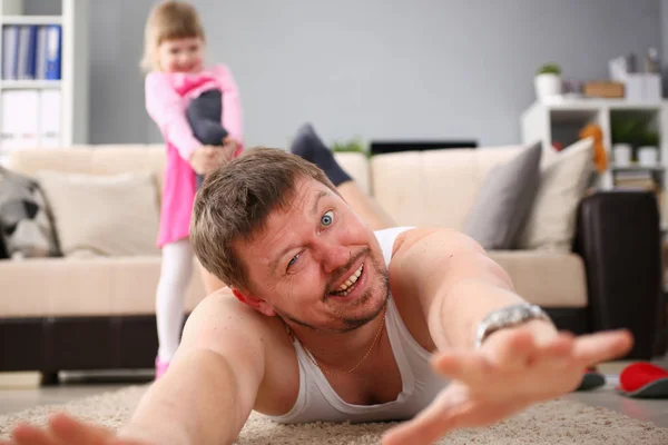 Cute little girl hold her father leg as proof of winning battle game — Stock Photo, Image