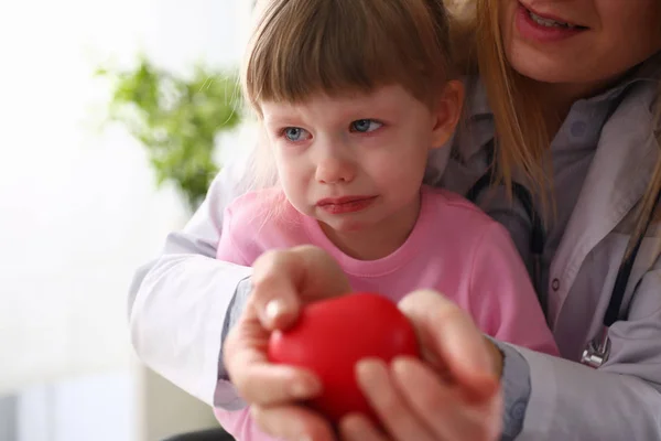 Malá vystrašená holčička, která navštěvuje lékaře držený v rukou červené hračky — Stock fotografie
