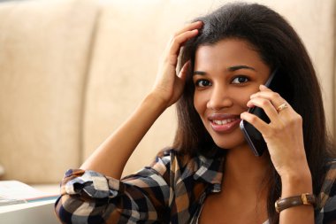 Kadın siyah gülümseyen tutun el cep telefonu evde