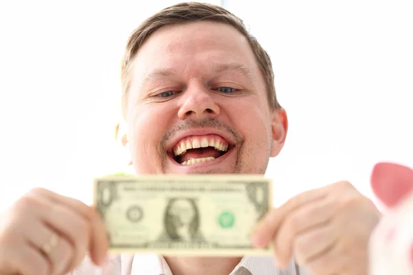 Manos masculinas sosteniendo un billete de un dólar haciendo algún punto sobre el éxito del negocio —  Fotos de Stock