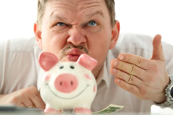 ピギーバンクからお金の香りを嗅ぐ面白いビジネスマン — ストック写真