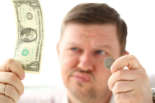 Arms of thoughtful man holding paper and coin currency Stock Image