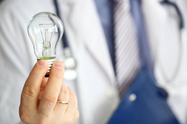 Parlak fikir buluş sembolü olarak ampul tutan erkek doktor el