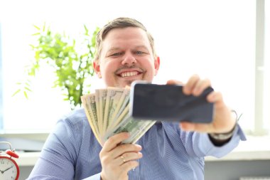 Para yığını ile poz cep telefonu kamerası ile kendini fotoğraf yapma Adam