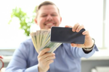Para yığını ile poz cep telefonu kamerası ile kendini fotoğraf yapma Adam