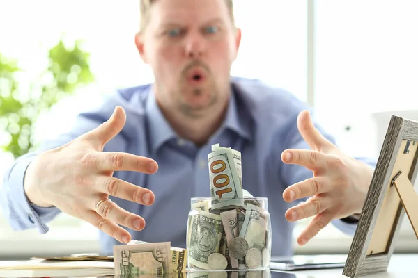 Mani maschili afferrare grande vaso grasso pieno di valuta degli Stati Uniti come gesto avidità — Foto Stock