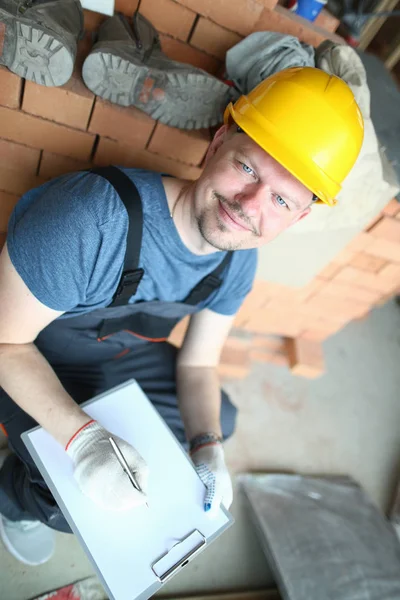 Mannelijke bouwer in gele harde hoed houdt — Stockfoto