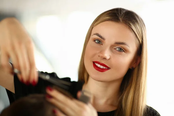 Belle femme coupe les cheveux masculins dans le salon de beauté — Photo