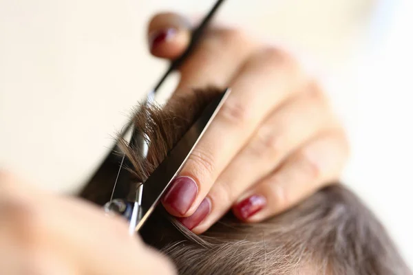 Dita femminili che tagliano i capelli maschili dalle forbici — Foto Stock