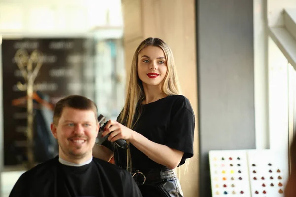 Молодая девушка парикмахер бритья улыбающийся мужчина клиент — стоковое фото