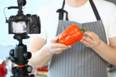 Şef vlogger gösteren kamera turuncu biber