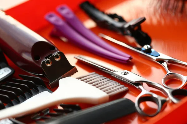 Tesoura e ferramenta de cabeleireiro em fundo vermelho — Fotografia de Stock