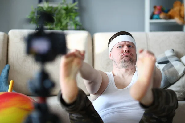 Funny man rekord ben stretching på digitalkamera — Stockfoto