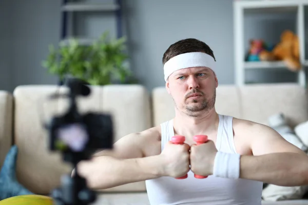 Hombre concentrado usando mancuerna para hacer ejercicio —  Fotos de Stock