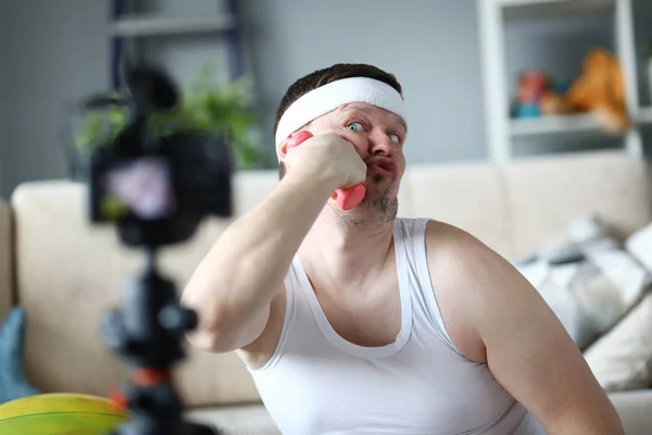 Rolig vlogger skämtar och sätta hantel till Face — Stockfoto