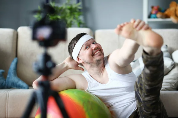 Hombre feliz haciendo estiramiento en Fitness Ball en casa —  Fotos de Stock