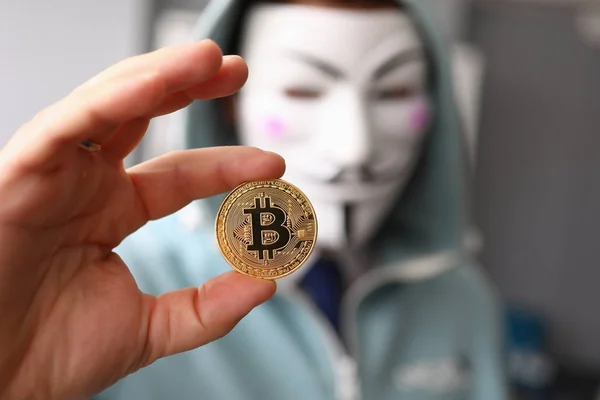 Hacker tragen anonyme Maske und halten Bitcoin in der Hand — Stockfoto