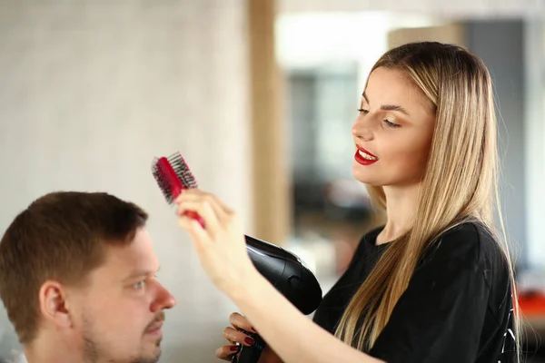 ヘアスタイルのためのヘアブラシを使用してブロンド美容師 — ストック写真