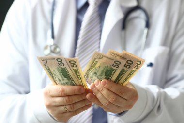 Doktorun erkek eli elinde dolar nakit yarıya