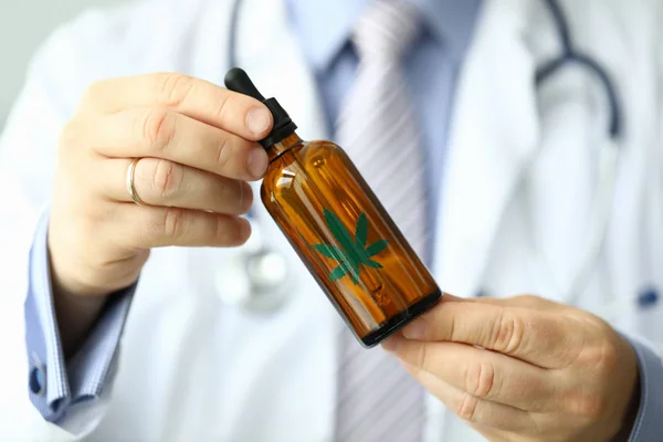 Мужчина врач держать бутылку с марихуаной — стоковое фото